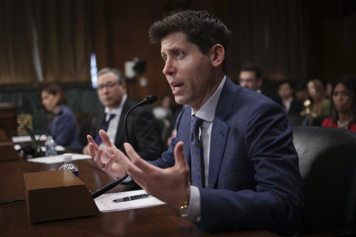 Sam Altman, CEO of OpenAI, sits at desk in front of microphones testifying to Senate committee