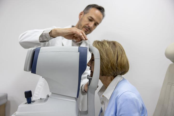 Male doctor performs eye exam on a female patient using OCT scanner