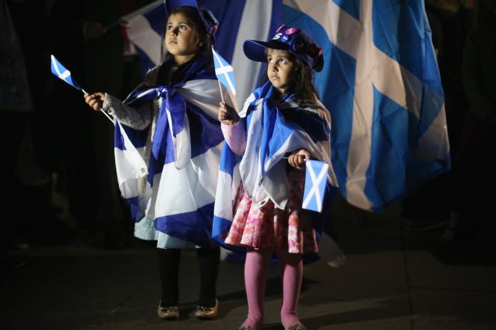 Two young girls covered in Scottish flags 