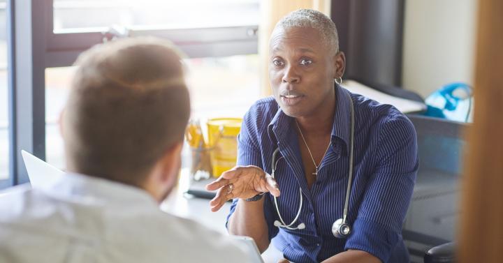 Female doctor talking to male patient in GP surgery
