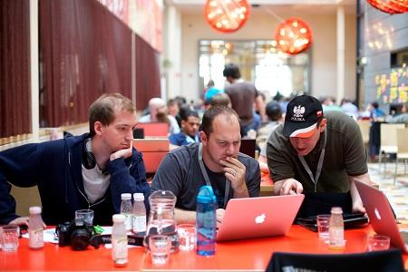 Three developers at a code sprint, sitting at a table.