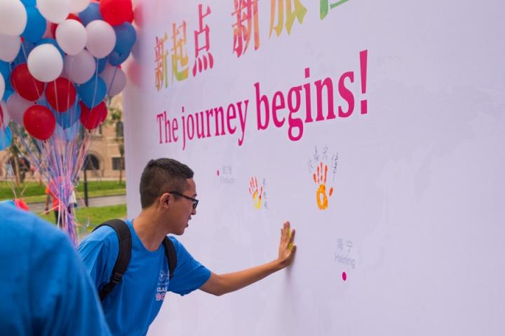 A student puts his handprint on a welcome wall at Zhejiang