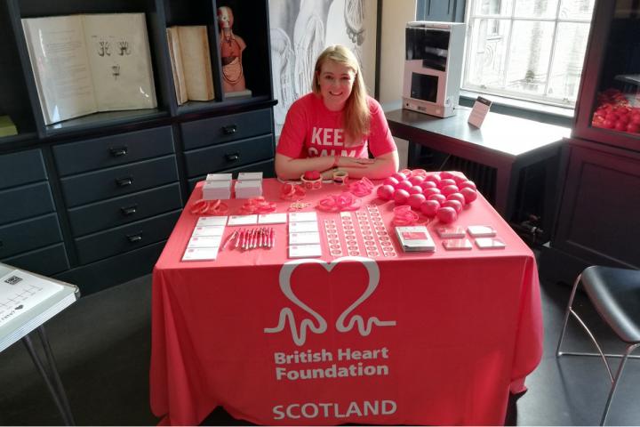 woman sits at British Heart Foundation merchandise table