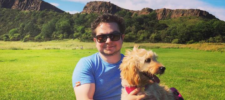 Ian LeBruce and his dog in Holyrood Park with the Crags in the background.