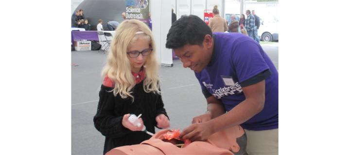Demonstator at Science Festival explains to child how lungs work 