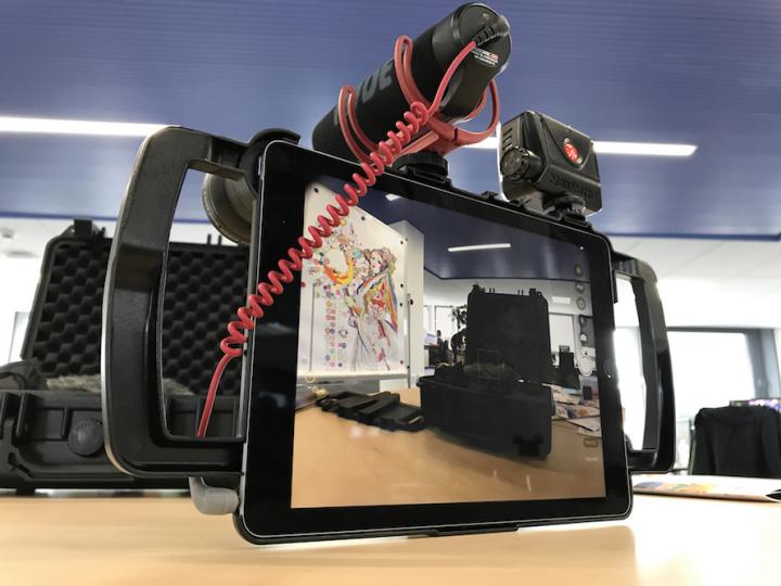 An iPad with a microphone and light attached