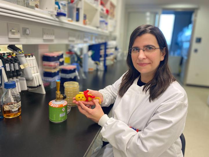 Dr Joana Alves in the lab holding a bacterium that she handcrafted.