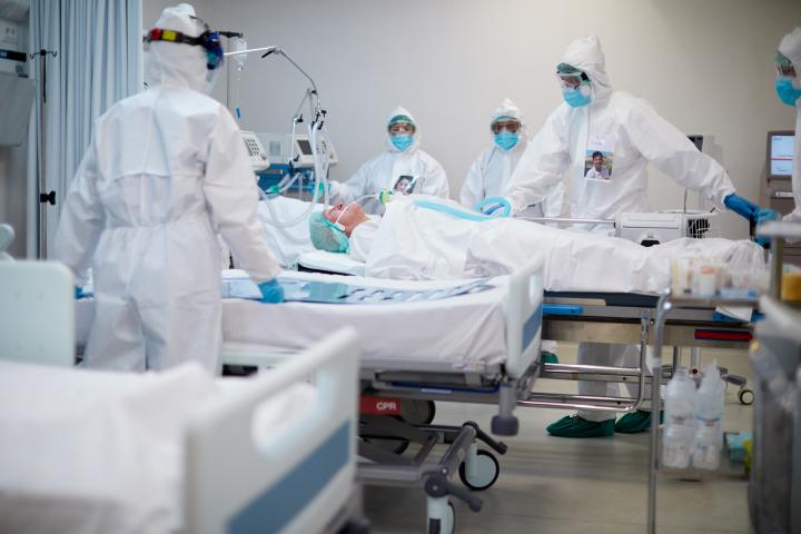 Image of clinical staff in full PPE working on patient in intensive care unit