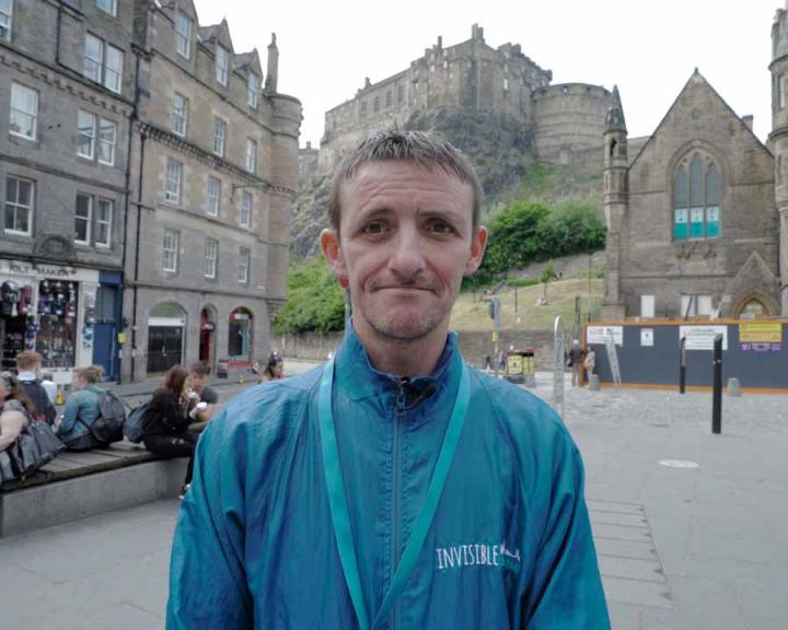A tour guide stands in the Grassmarket area of Edinburgh