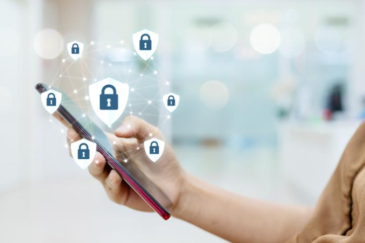 Image of smartphone being held in a hand with padlock icons hovering around the screen