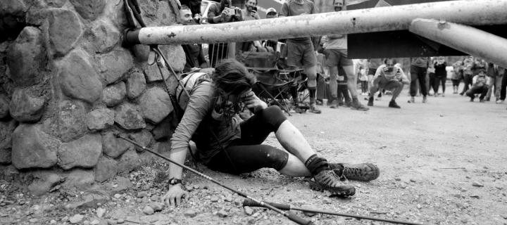 Jasmin Paris slumped at Barkley Marathons finish line with photographers and onlookers in the background 