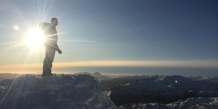 Man ontop of mountain in the snow