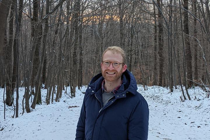 Photo of Mark Bradshaw standing in a forest looking at the camera
