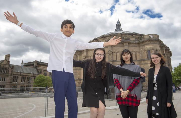 Two pupils and their mentors stand in front of McEwan Hall