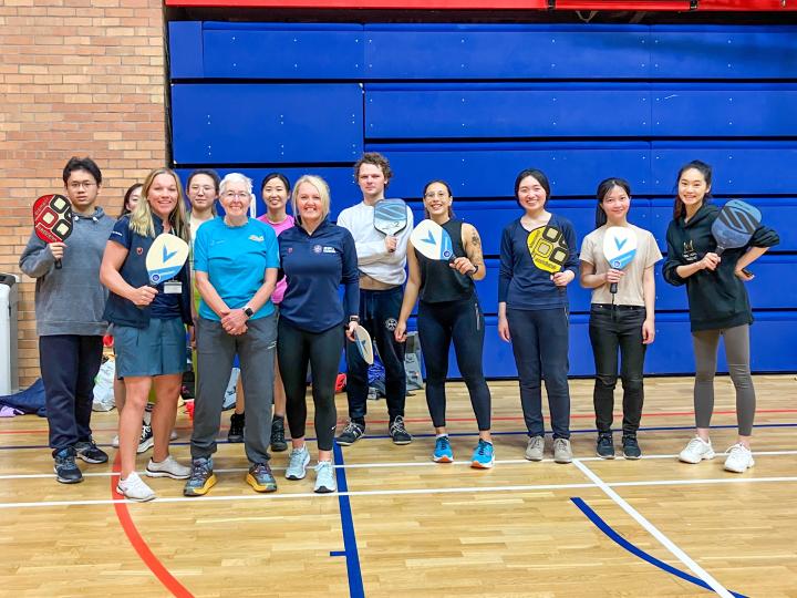 Group of students and staff lined up in a row after playing pickleball