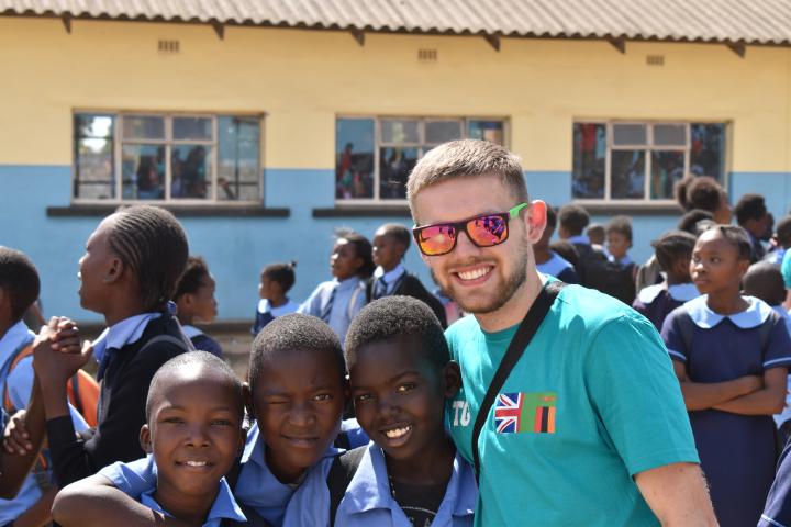 student pictured with Zambian children