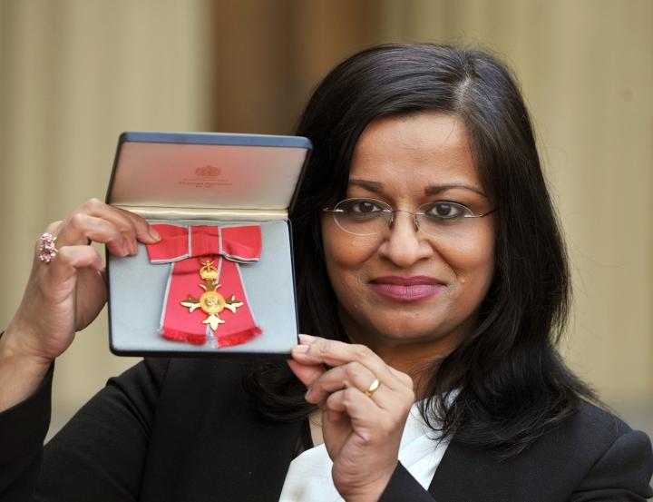 Mona Siddiqui holds up a case containing her OBE medal. 