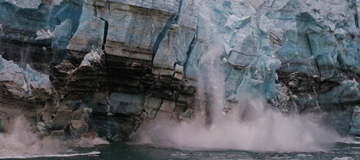 Melting ice from a glacier breaks off and crashes into the ocean due to climate warming