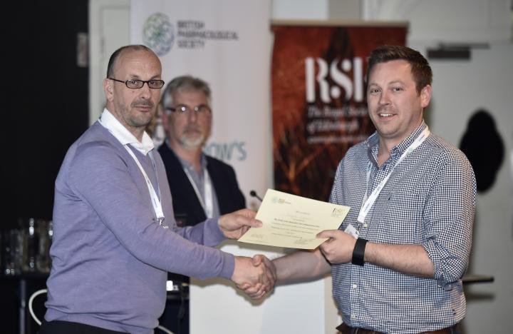 Douglas Gibson receiving a prize certificate from conference organisers