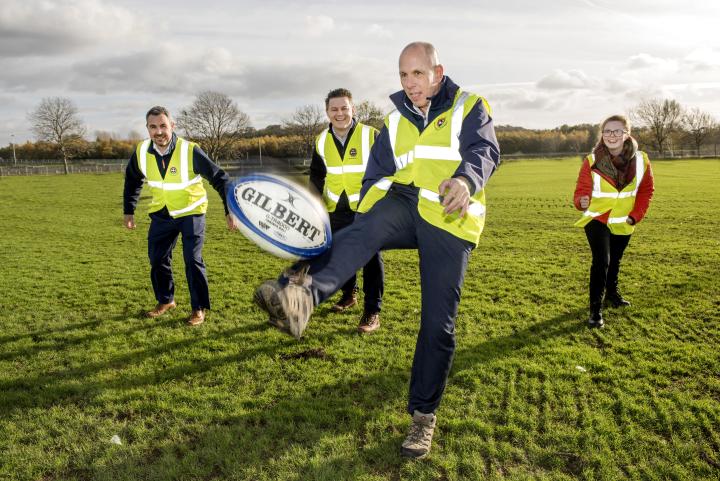 Director of Sport Jim Aiken kicking a rugby ball at 3G pitch opening