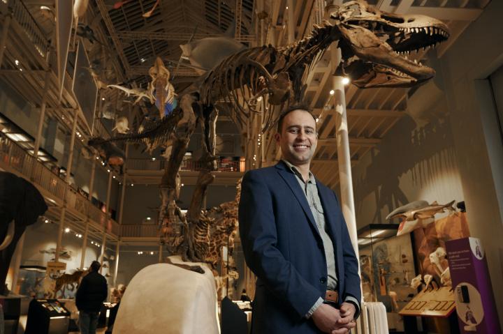 Steve Brusatte underneath a dinosaur skeleton 