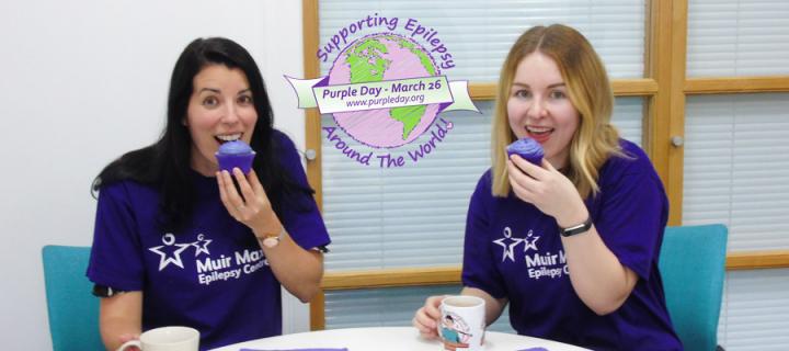 Two alumni team members eating purple cupcakes on Purple Day