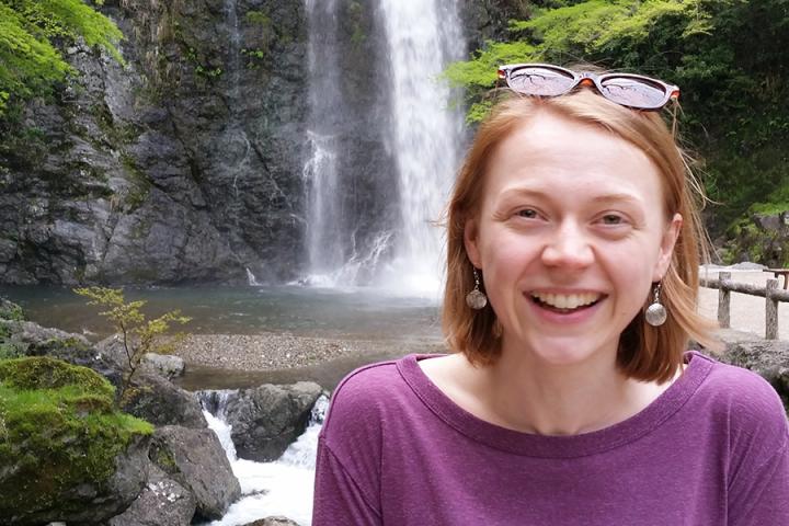 Photograph of Rosie Hedger in front of a waterfall