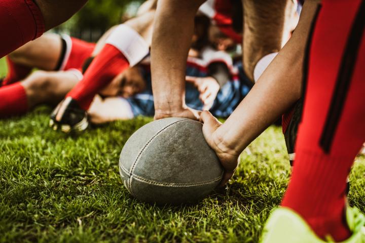 Close up of a rugby scrum with players legs and ball visible