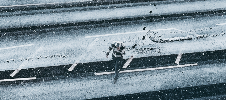 man crossing road in snow