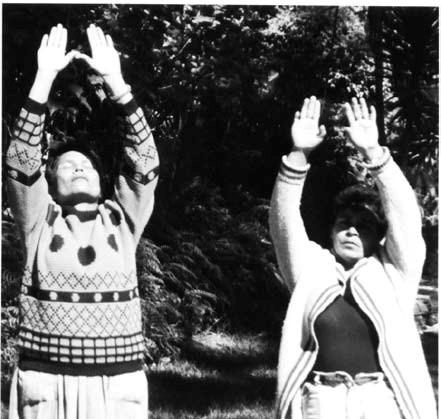 Photograph of two people doing the salute to the sun yoga practice stance in Honduras