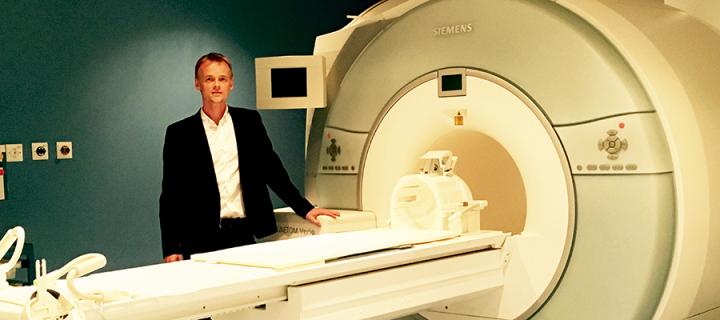 Scott Semple standing by an MRI machine
