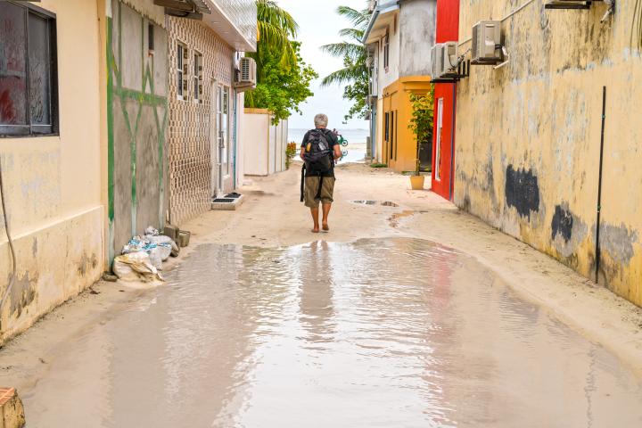 Small street in the Maafushi island in Maldives flooded with rain water