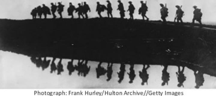 Soldiers walking along the horizon and reflected in the water