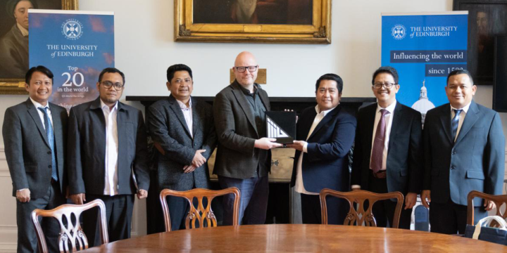 James Smith exchanges gifts with representatives from MoRA, IIIU, and the British Council