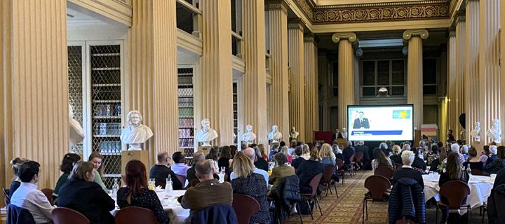 A crowd shot of attendees sitting at tables in Edinburgh's Playfair Library