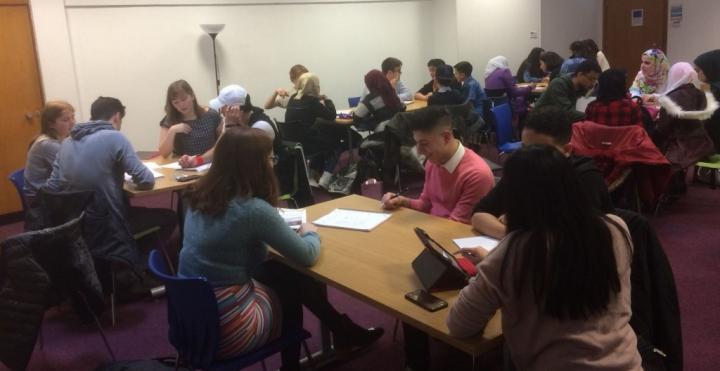Photograph of Friday tutoring session in the Chaplaincy centre. Photograph shows groups of tutors and students sitting working at desks. 