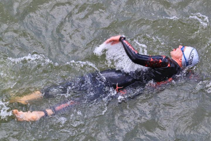a man swimming in water with a wetsuit on