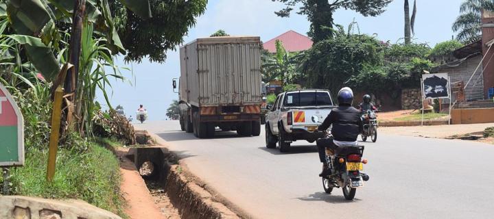 A lorry, car and motorbike on a road in Kampala, Uganda