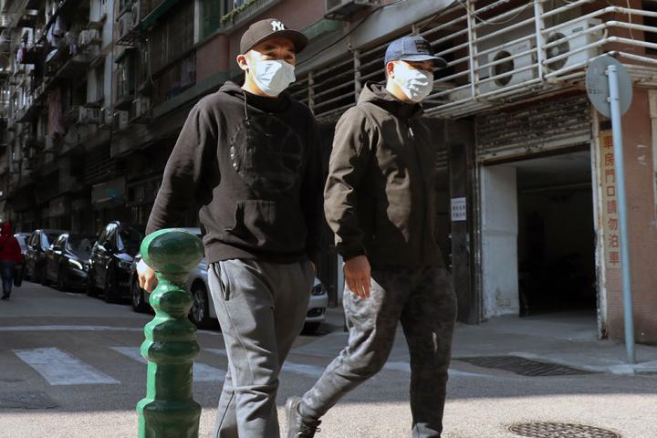 Two men walking and wearing face masks