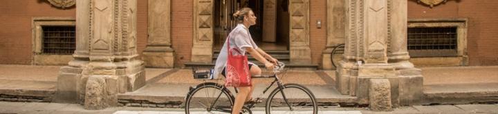Women riding a bike on Bologna campus 