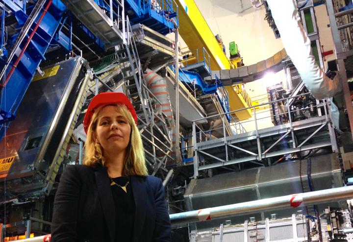 Professor Victoria Martin standing by the ATLAS experiment at LHC.