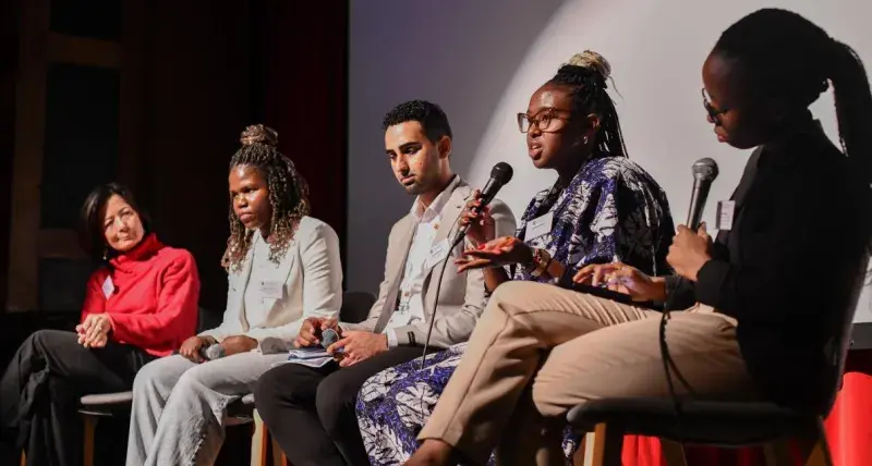 A group of five people take part in an on stage discussion. 