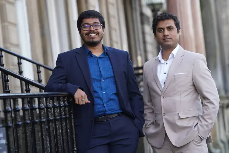 Founders of Qinara standing by railings 