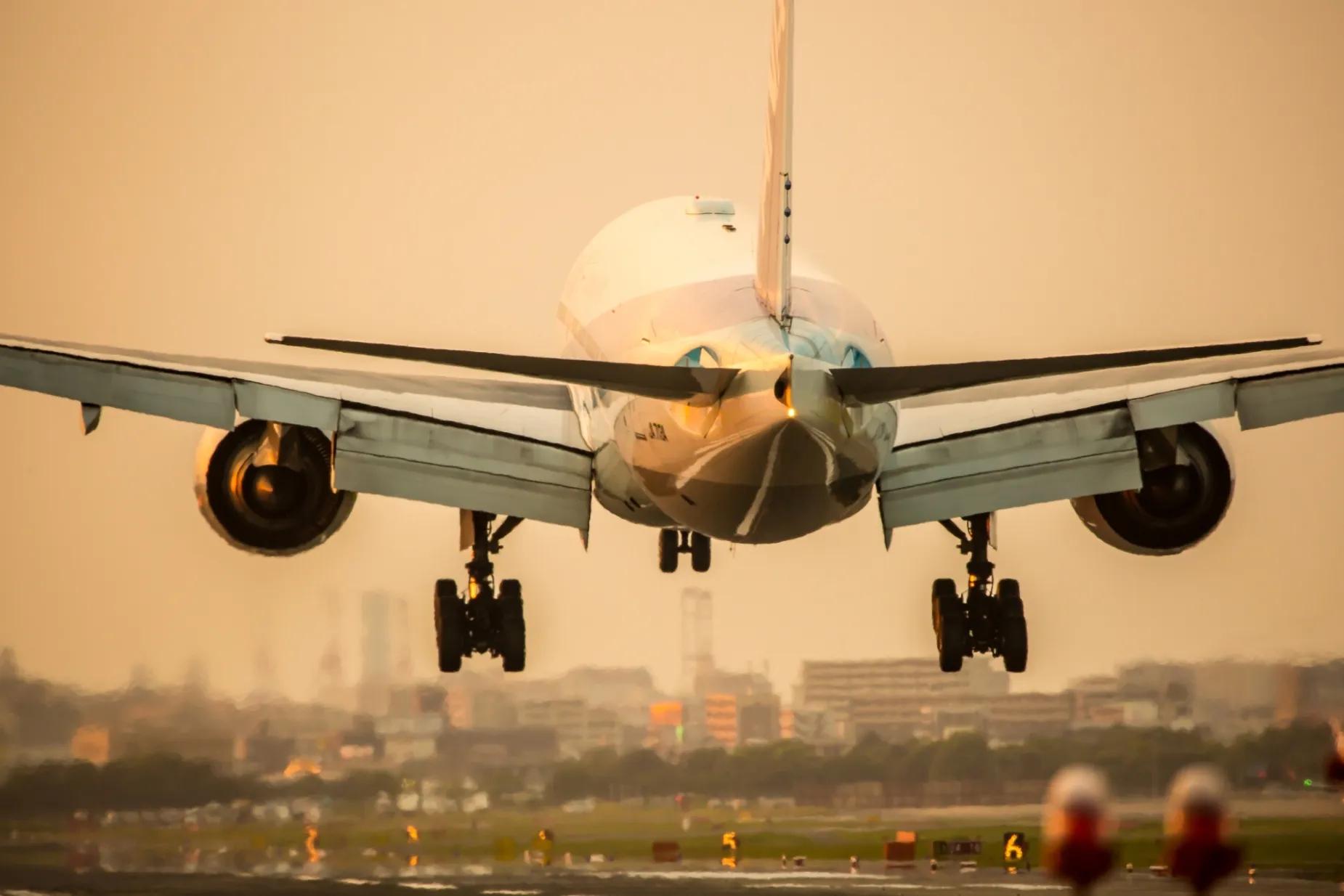 Large aeroplane taking off with buildings in the background