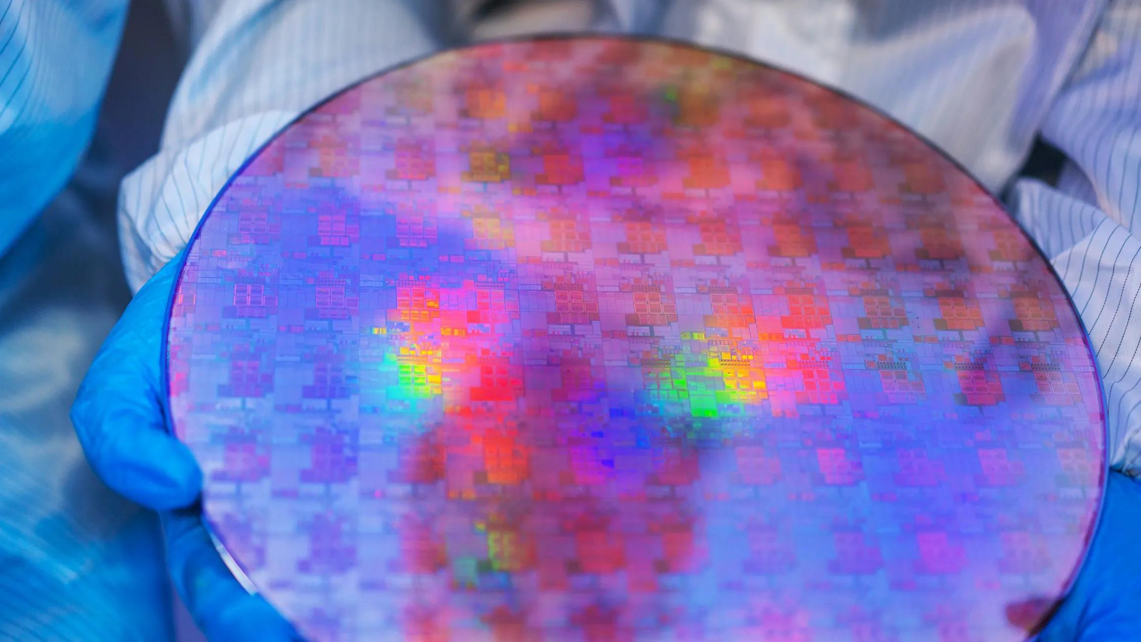 Scientist holding a circular silicon wafer chip