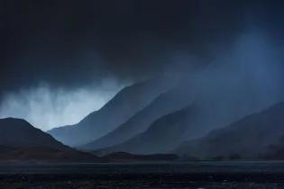 Dark rain clouds over a Scottish mountain range