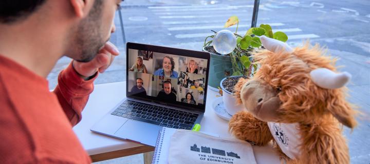 Student watching video lecture on laptop in cafe