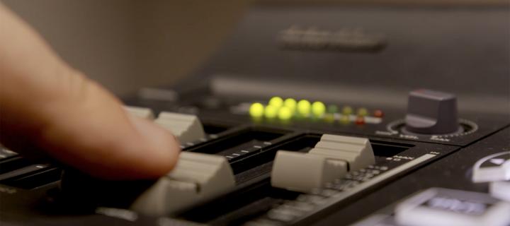 A finger is seen moving a button on a production deck