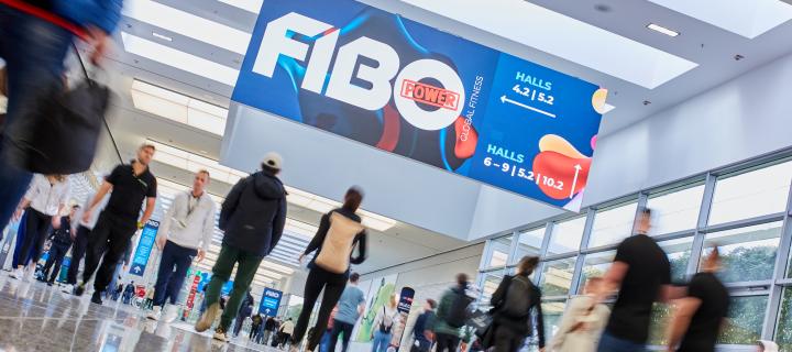 Image of corridor with attendees under a sign with the words FIBO