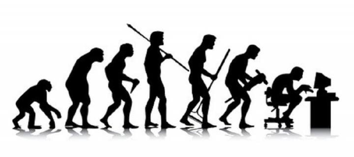 Image of evolution silhouettes, the last silhouette is a person sitting at a computer. 